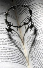 Open book with small crown of thorns making the shape of a heart with it's shadow