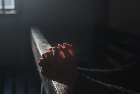 Person praying at a pew